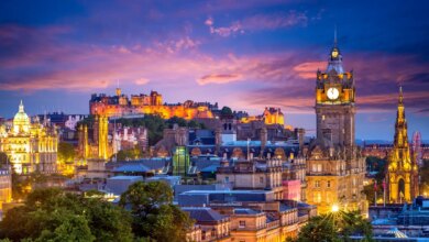 Panoramica di Edimburgo illuminata al tramonto con una torre dell'orologio sul lato destro