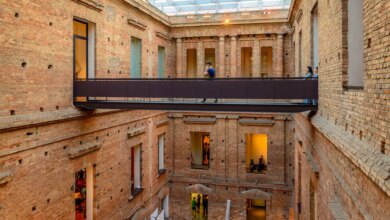 Puentes de acero en un patio interior de ladrillo donde se pueden ver varias ventanas y un techo con cristaleras en la Pinacoteca del Estado de São Paulo.