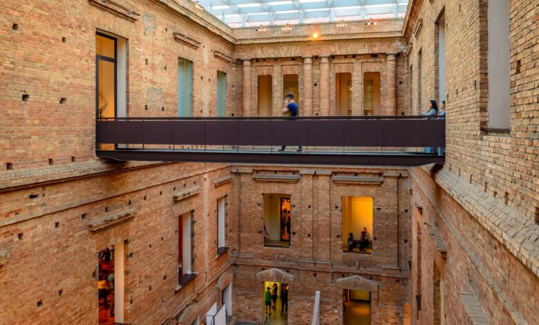 Puentes de acero en un patio interior de ladrillo donde se pueden ver varias ventanas y un techo con cristaleras en la Pinacoteca del Estado de São Paulo.