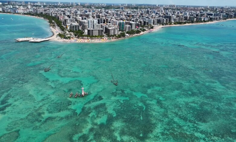 Vista aérea da cidade de Maceió com as águas turquesas e a cidade ao fundo