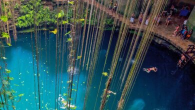 Cenote Ik Kil visto de cima com várias pessoas nadando no seu interior