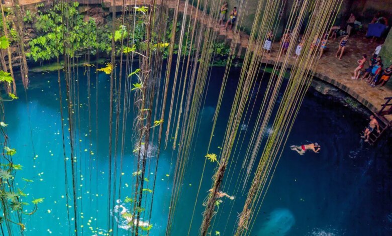 Cenote Ik Kil visto de cima com várias pessoas nadando no seu interior