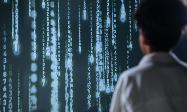 An individual viewing glowing numbers on a screen, symbolizing technology and data.